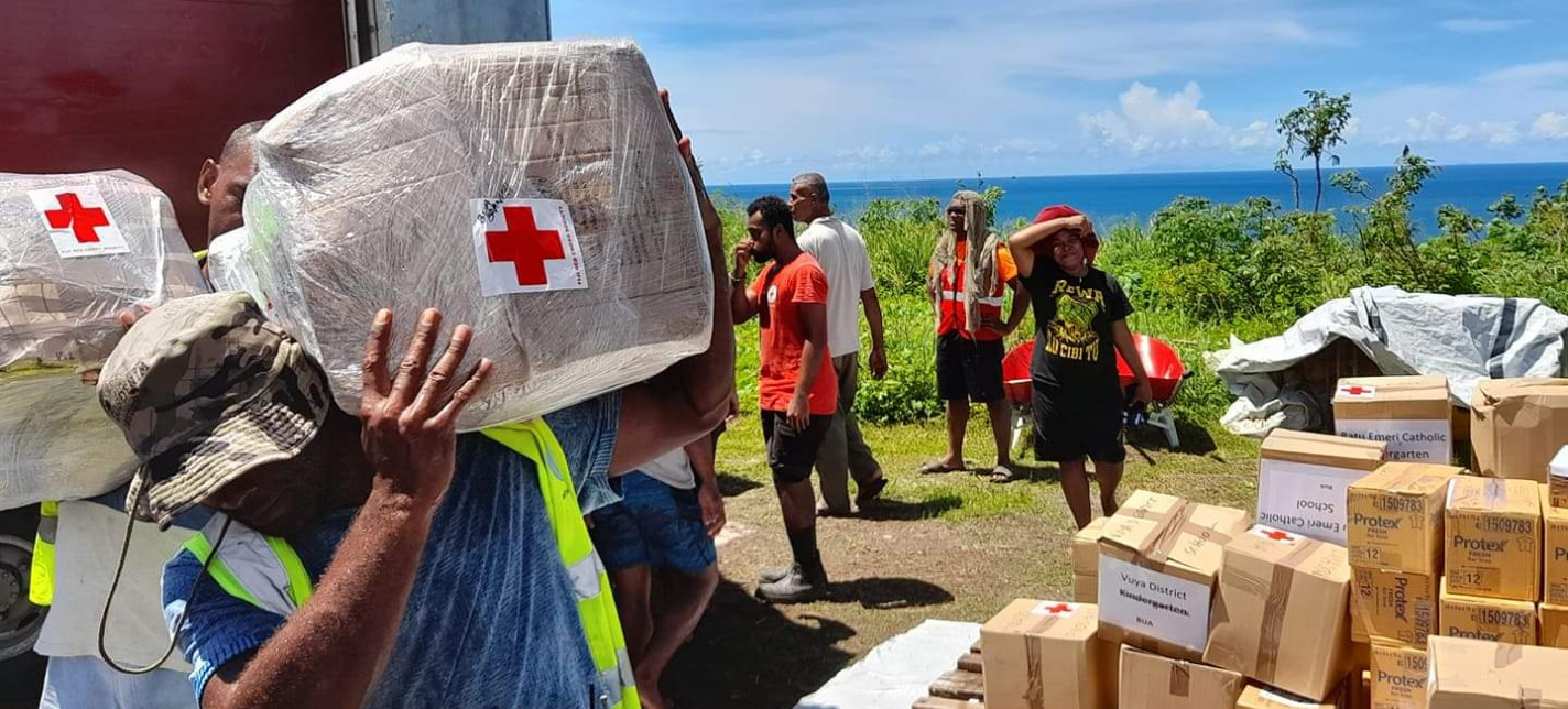 Red Cross volunteers unpack boxes from a truck