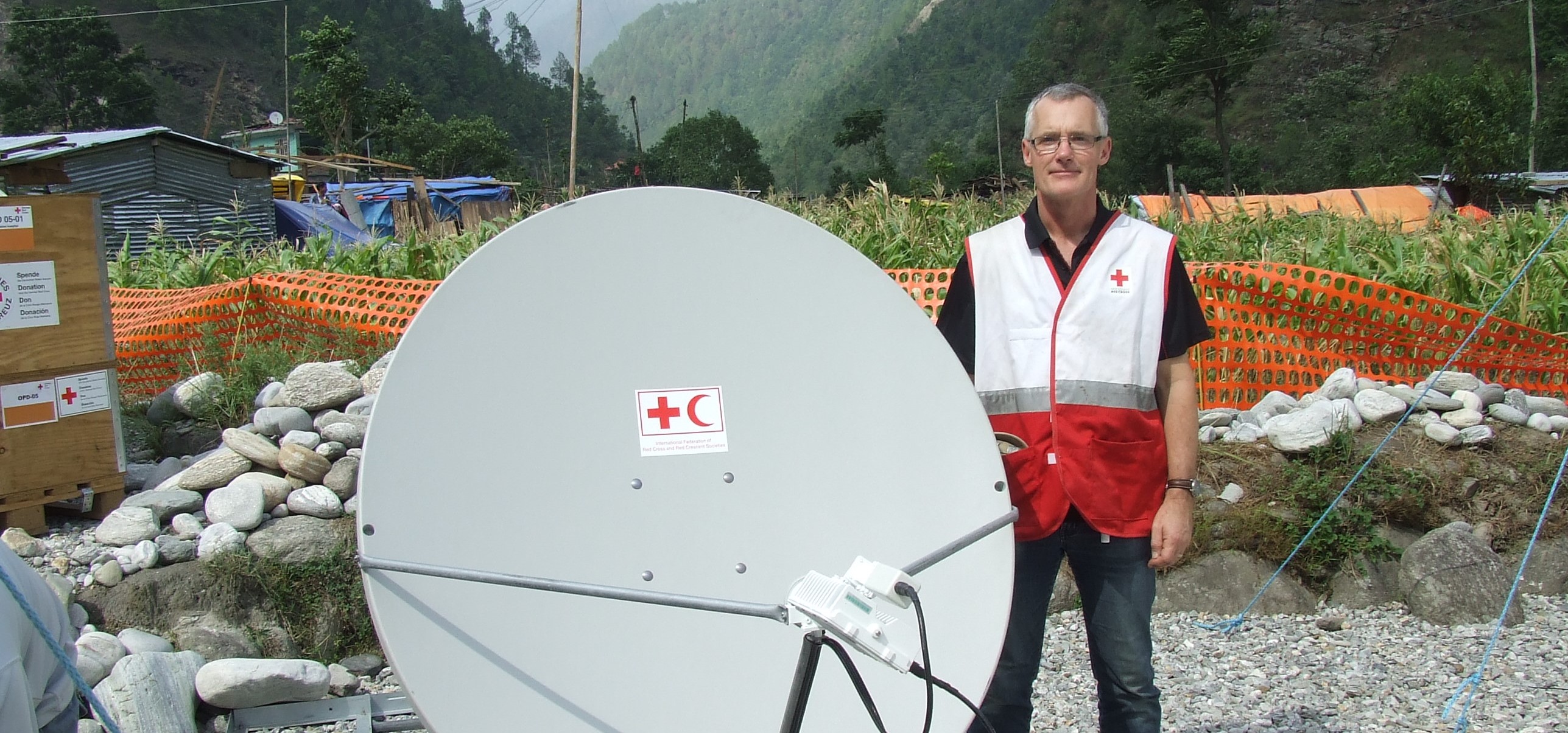 A man standing next to a satellite dish. 