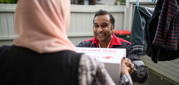 Red cross volunteer delivering care package to family