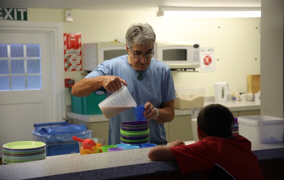 A man serving a child breakfast.