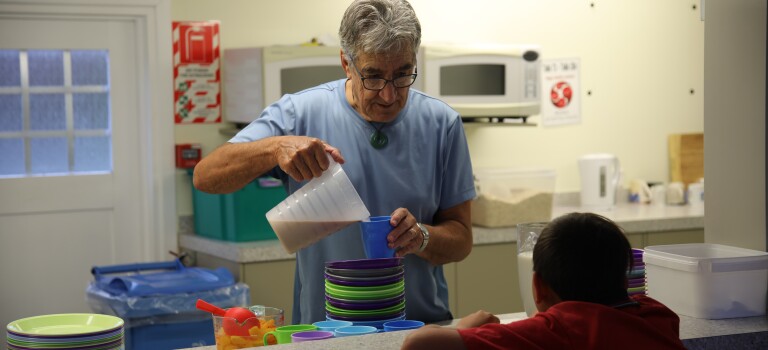 A man serving a child breakfast.