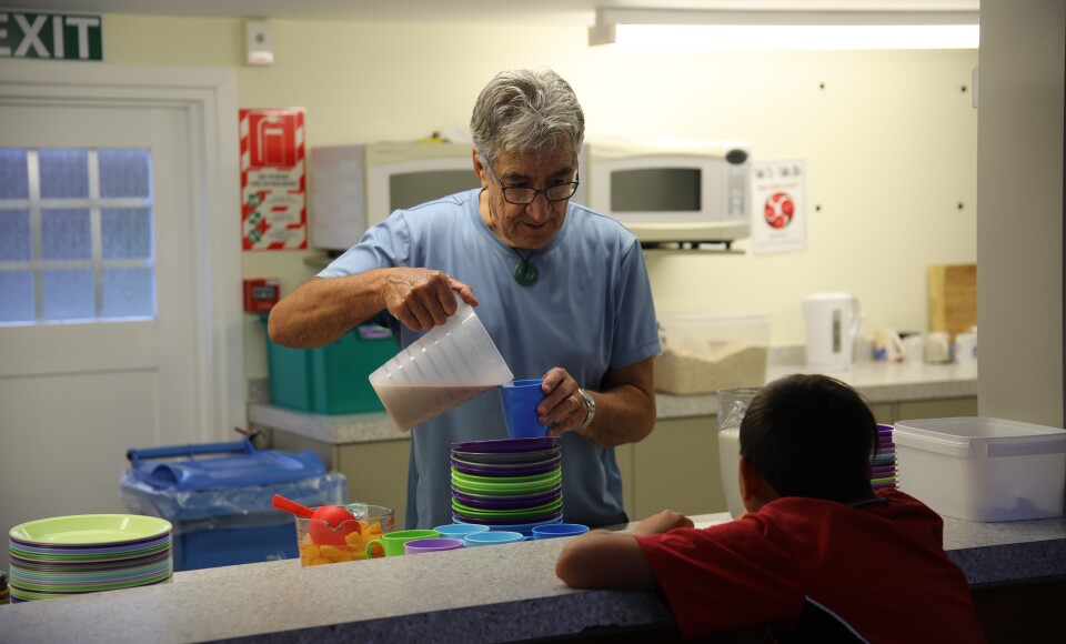 A man serving a child breakfast.