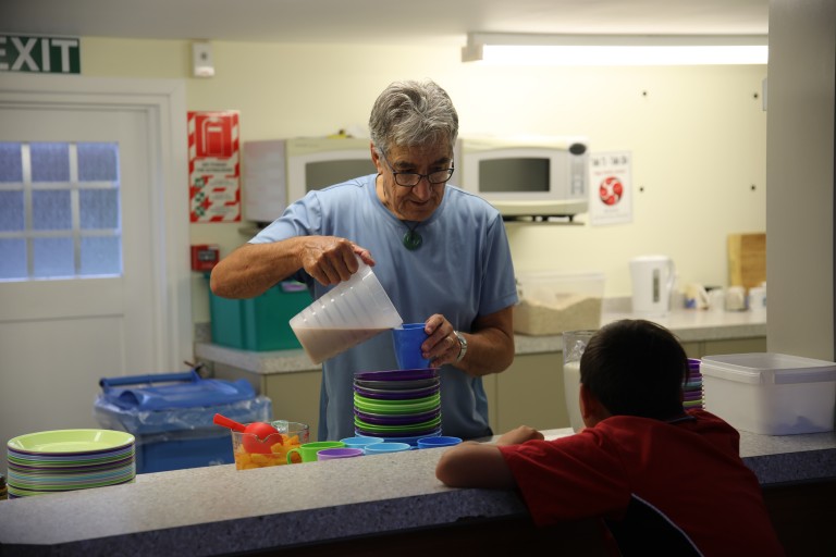 A man serving a child breakfast.