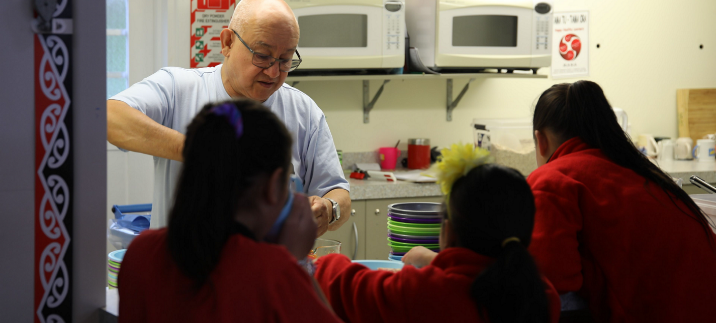 A man serving children breakfast.