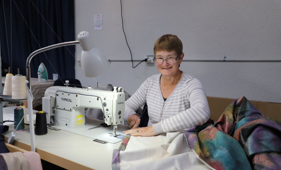 A woman at a sewing machine.