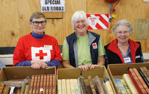 Three women standing in front of a book display.