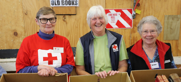 Three women standing in front of a book display.