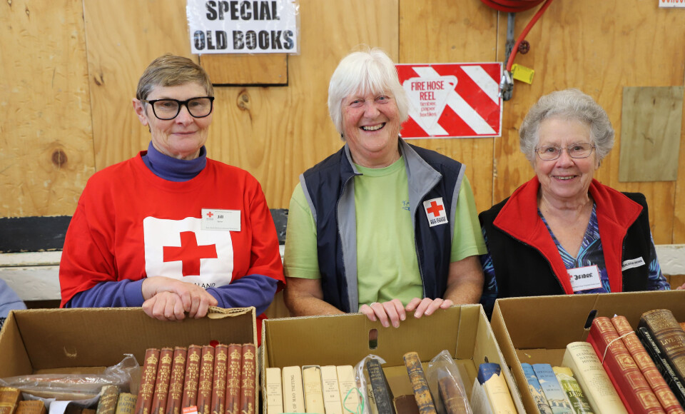 Three women standing in front of a book display.