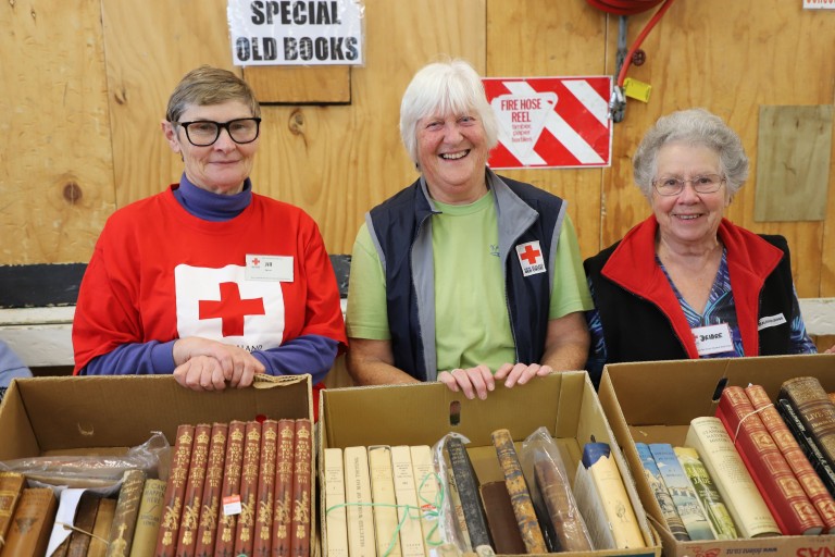 Three women standing in front of a book display.