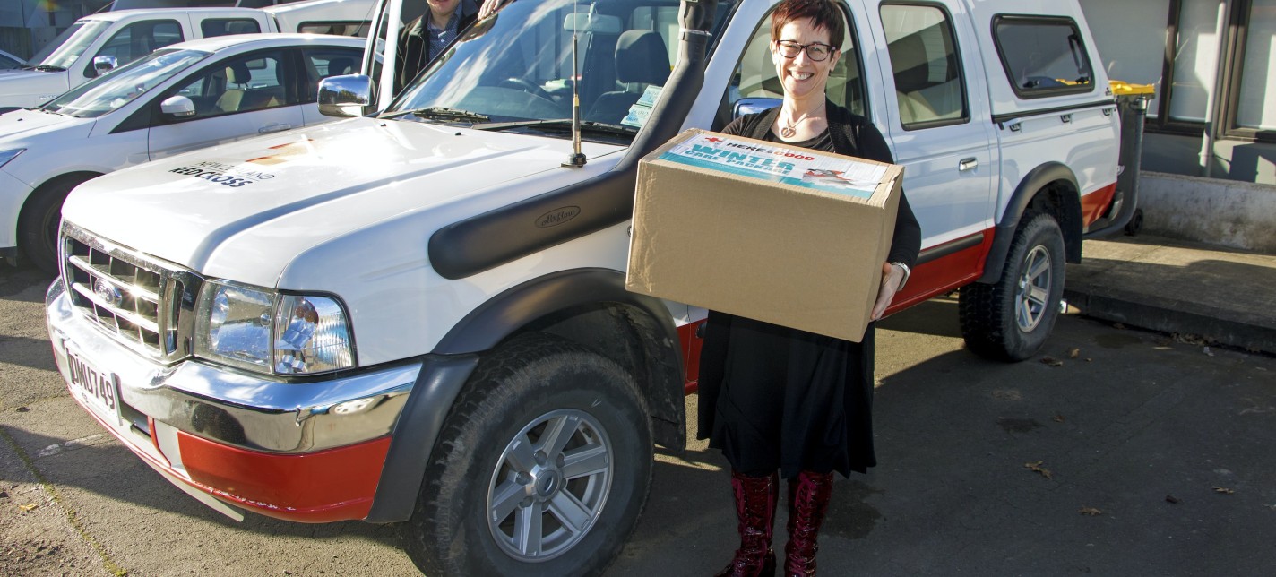 A man and a woman standing next to a ute. 
