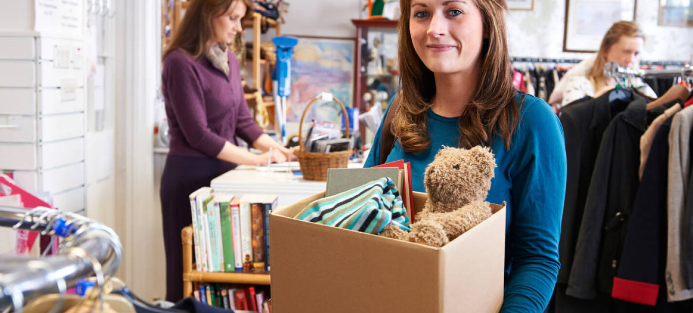 Woman holding a box of donated items for the Red Cross shop