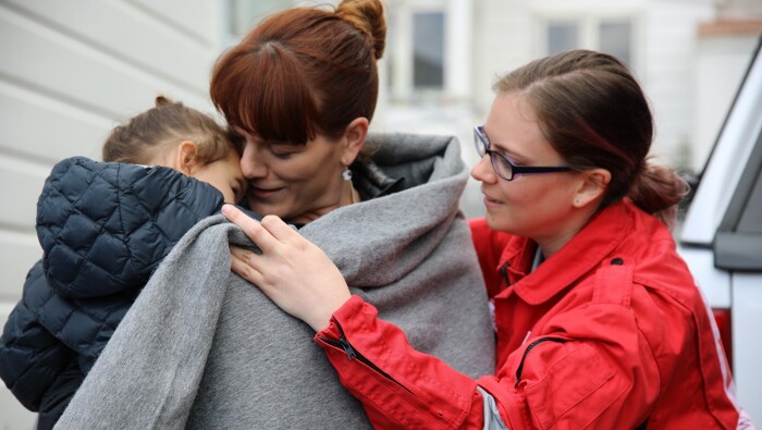 A woman and child wrapped in a blanket